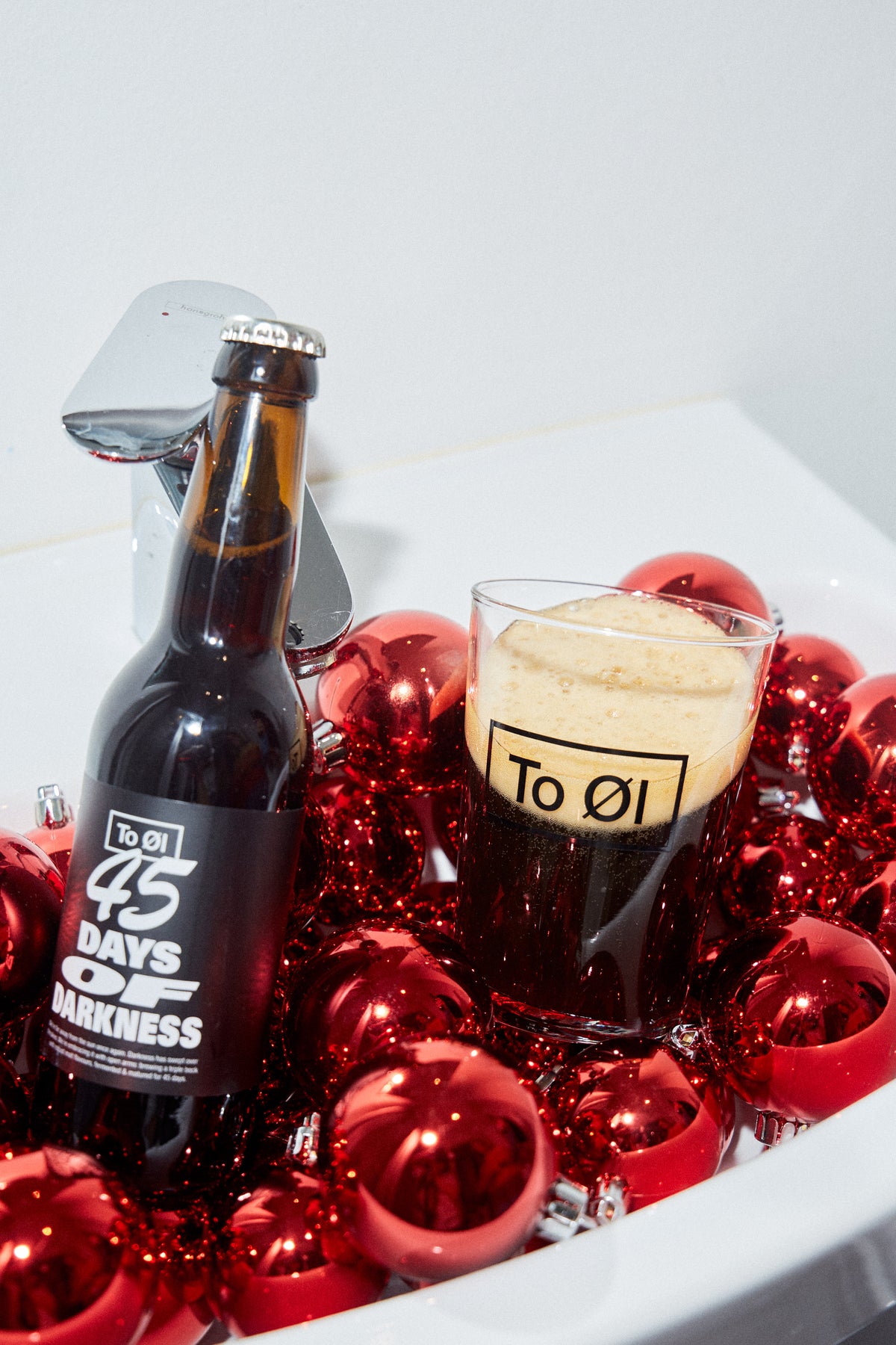 45 days of darkness dark battle pured in To Øl beer glas with christmas decoration and white background.