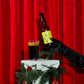 To Øl Jule Malt Bottle and Beer Glass Pour with Christmas setting and red background.