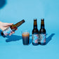 Two Mash Test Yummies bottles by To Øl featuring a poured beer glass placed on a blue background.