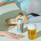 A lifestyle shot featuring a can of To Øl Wheat in Motion Beer IPA next to a glass of beer with foam, styled with ballet shoes and a dancer's hand and torso on a white surface.