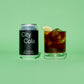 City Cola silver and black can and glass with cola on a green background